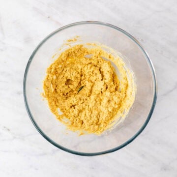 Mashed tofu mixed with mayonnaise, mustard, and spices in a bowl
