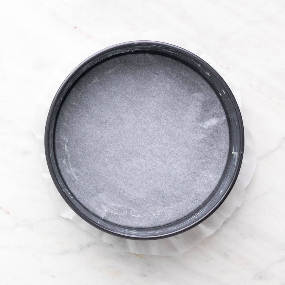Greased 9-inch cake pan lined with parchment paper