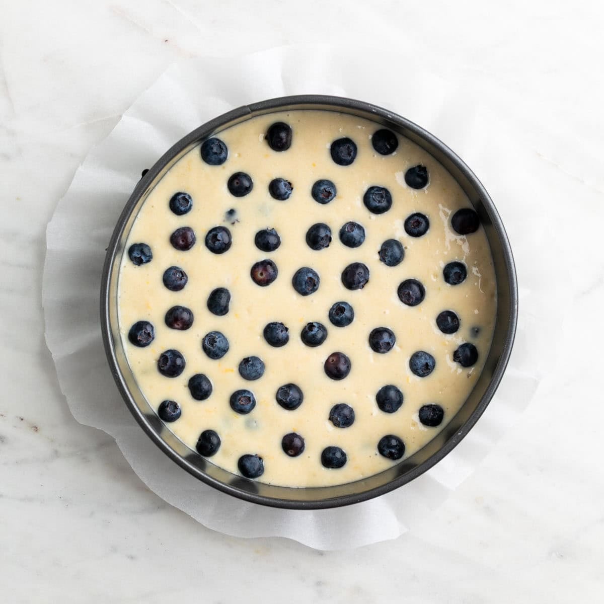 Cake batter with blueberries poured into the baking pan