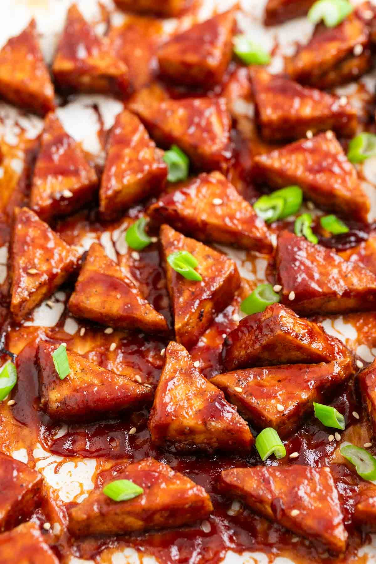 Crispy BBQ tofu triangles with sesame seeds and green onions
