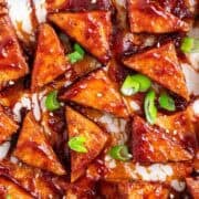 Sticky BBQ tofu triangles served with sesame seeds and green onions