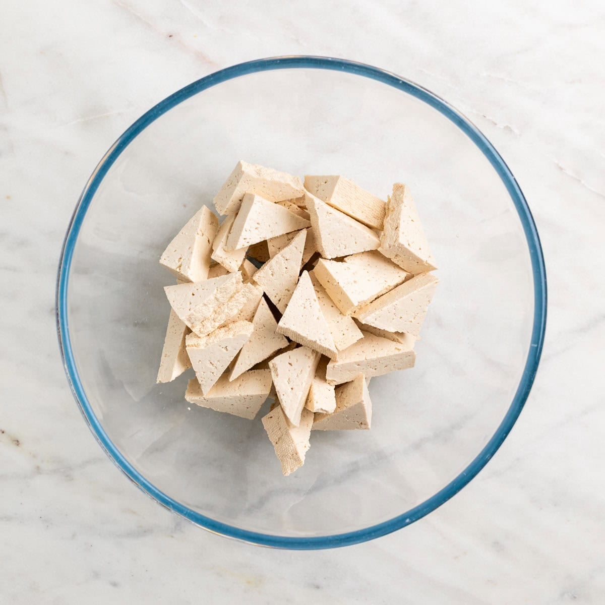 Tofu triangles in a mixing bowl