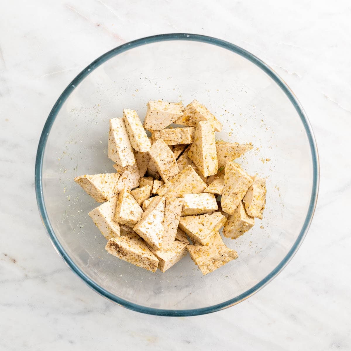 Tofu triangles coated with olive oil, garlic powder, salt, and black pepper