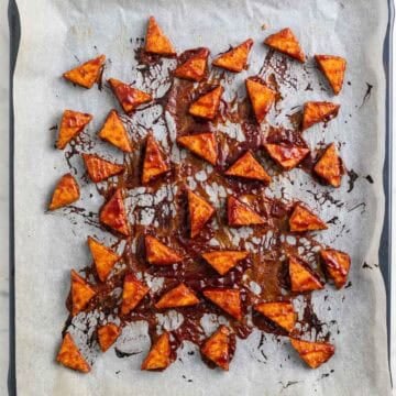 Baked BBQ tofu triangles on a baking sheet