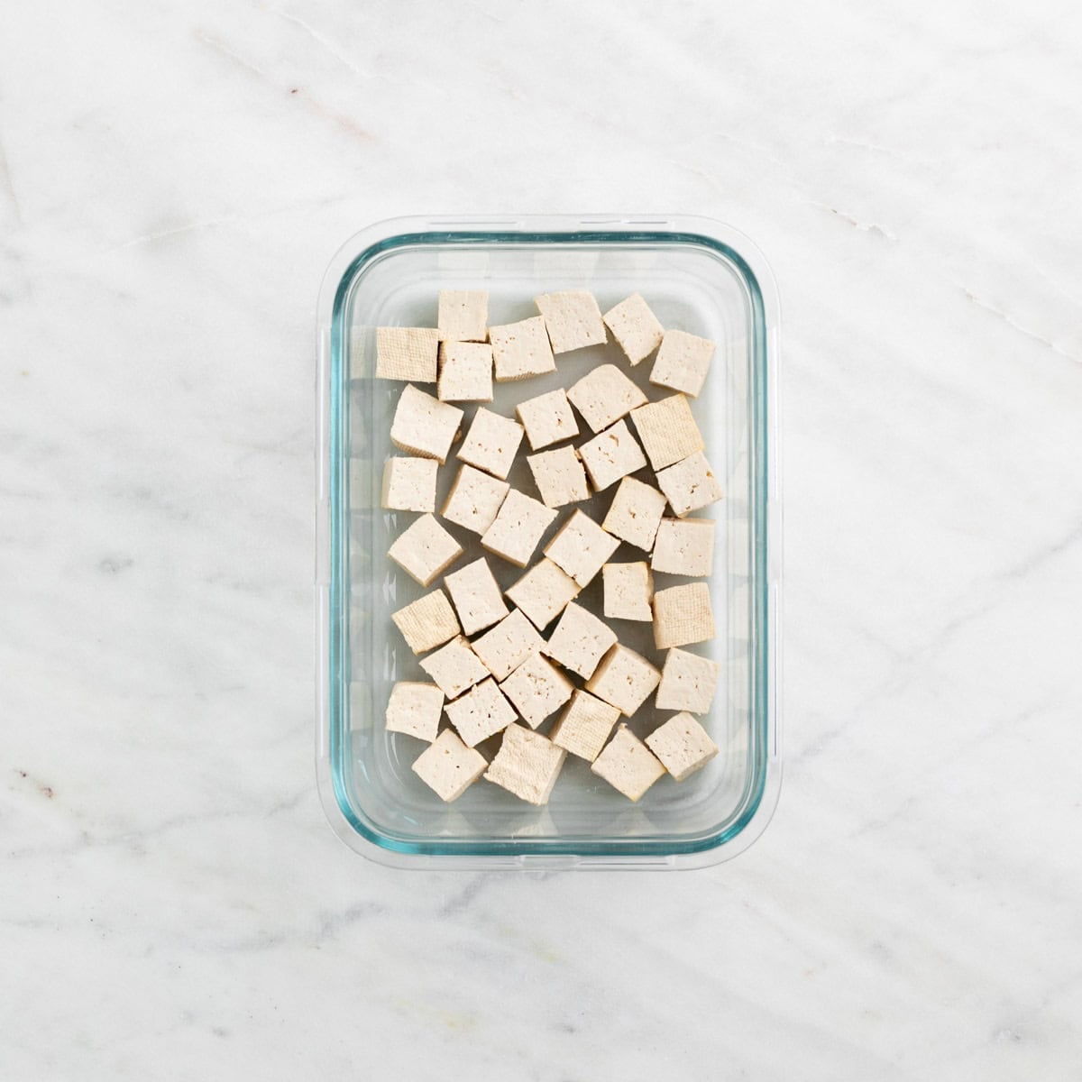 Frozen and thawed tofu cubes in a container