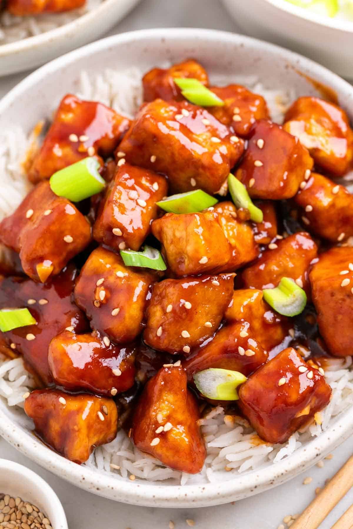 Korean BBQ tofu with rice topped with sesame seeds and sliced green onions