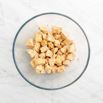 Torn tofu pieces coated with soy sauce in a bowl