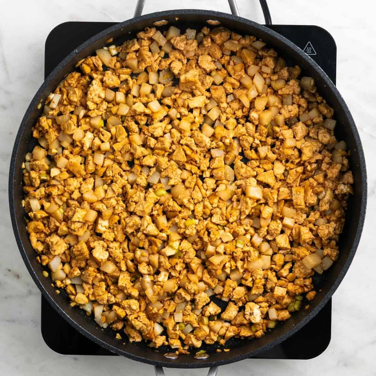 Crumbled tofu with sauce and water chestnuts in a skillet