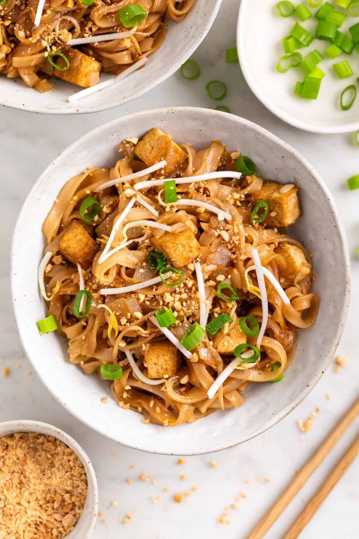 Tofu pad Thai served in a bowl with toppings