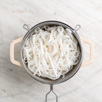 Cooked rice noodles drained in a colander