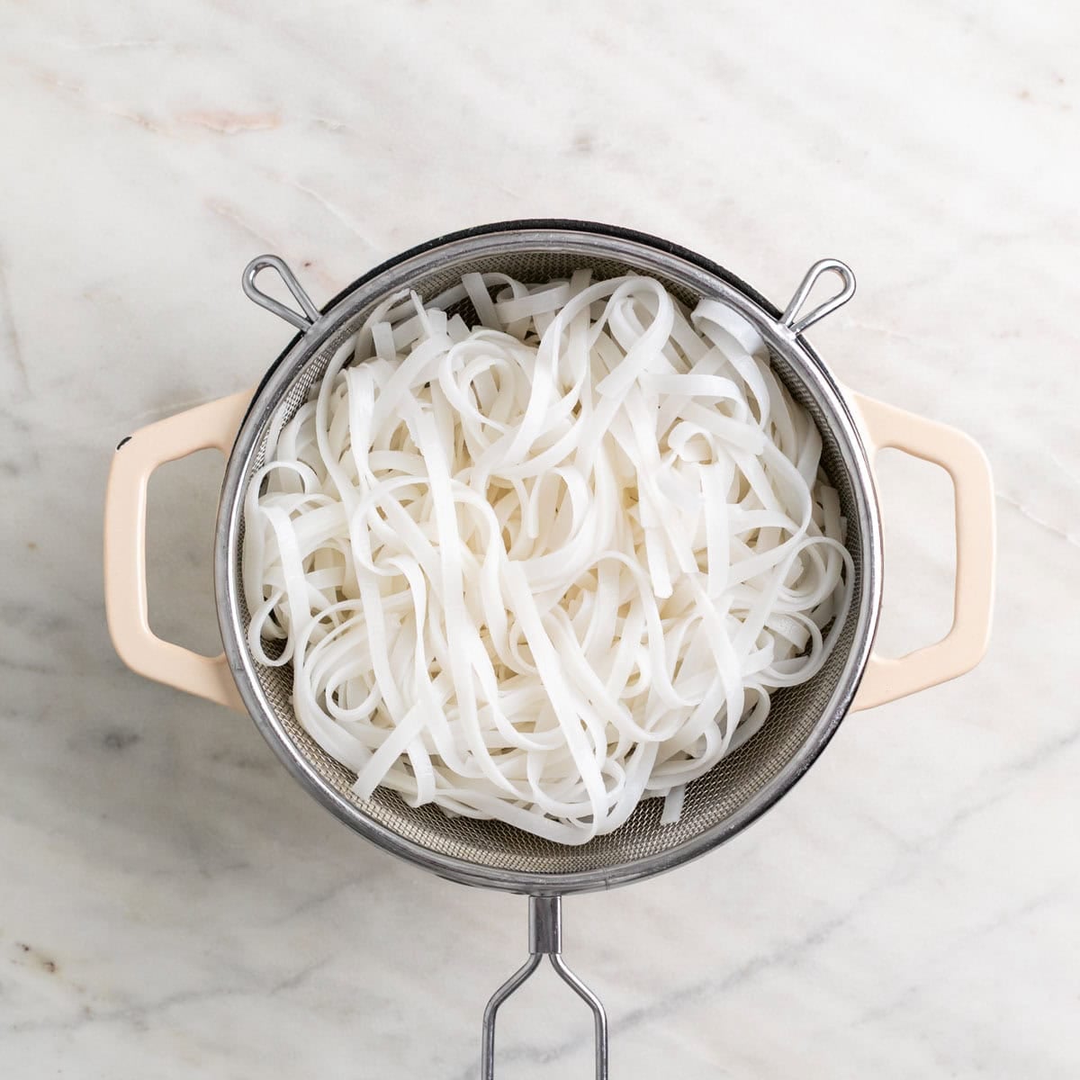 Cooked rice noodles drained in a colander