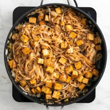 Tofu pad Thai cooking in a skillet