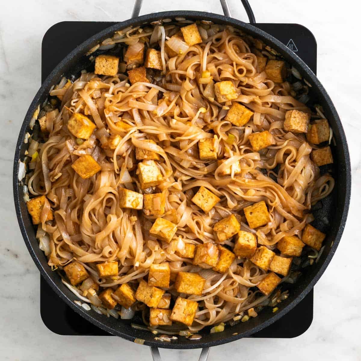 Tofu pad Thai cooking in a skillet