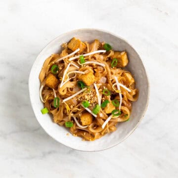 Tofu pad Thai served in a bowl with toppings