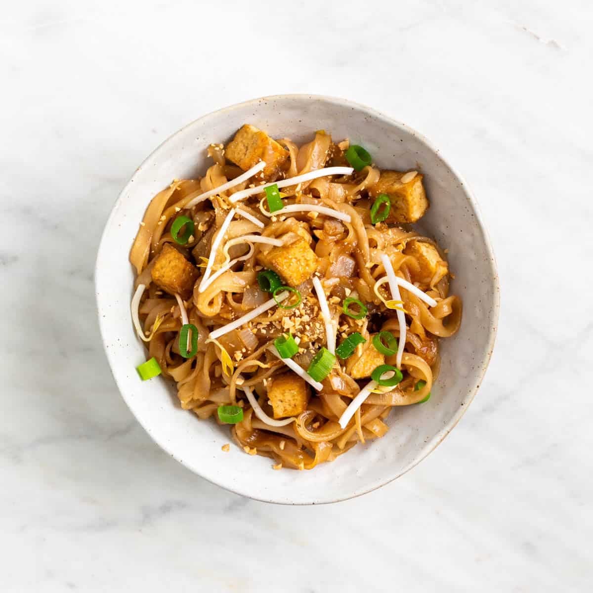 Tofu pad Thai served in a bowl with toppings