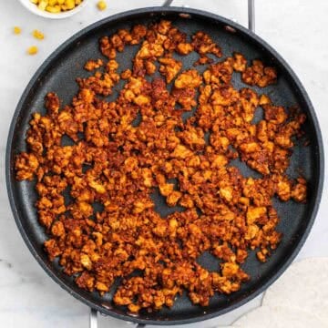 Tofu taco meat in a pan with corn and tortillas ready to serve