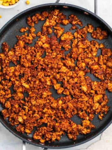 Tofu taco meat in a pan with corn and tortillas ready to serve