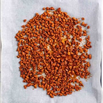 Marinated TVP spread onto a parchment-lined baking sheet before baking