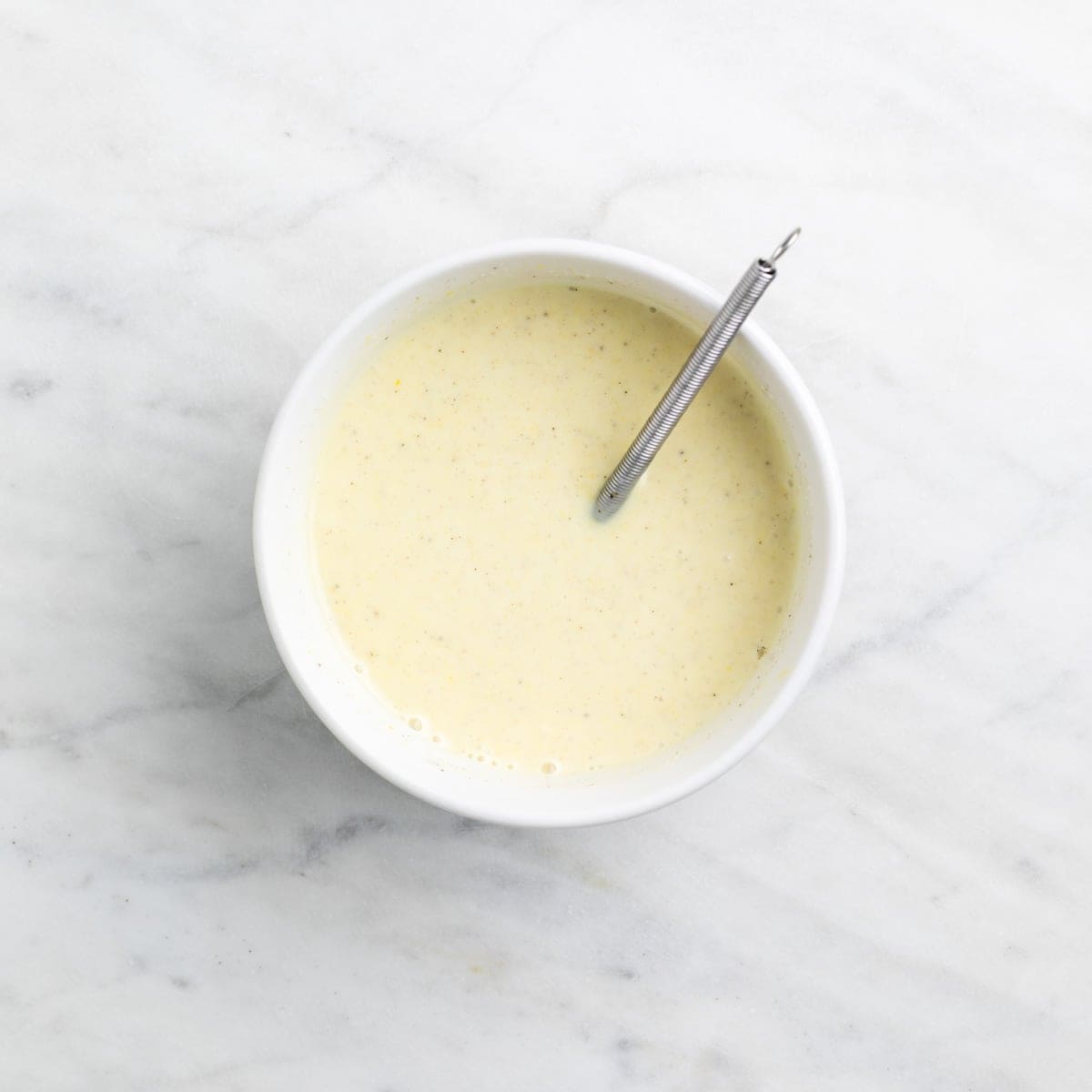 Creamy vegan macaroni salad dressing mixed in a small bowl
