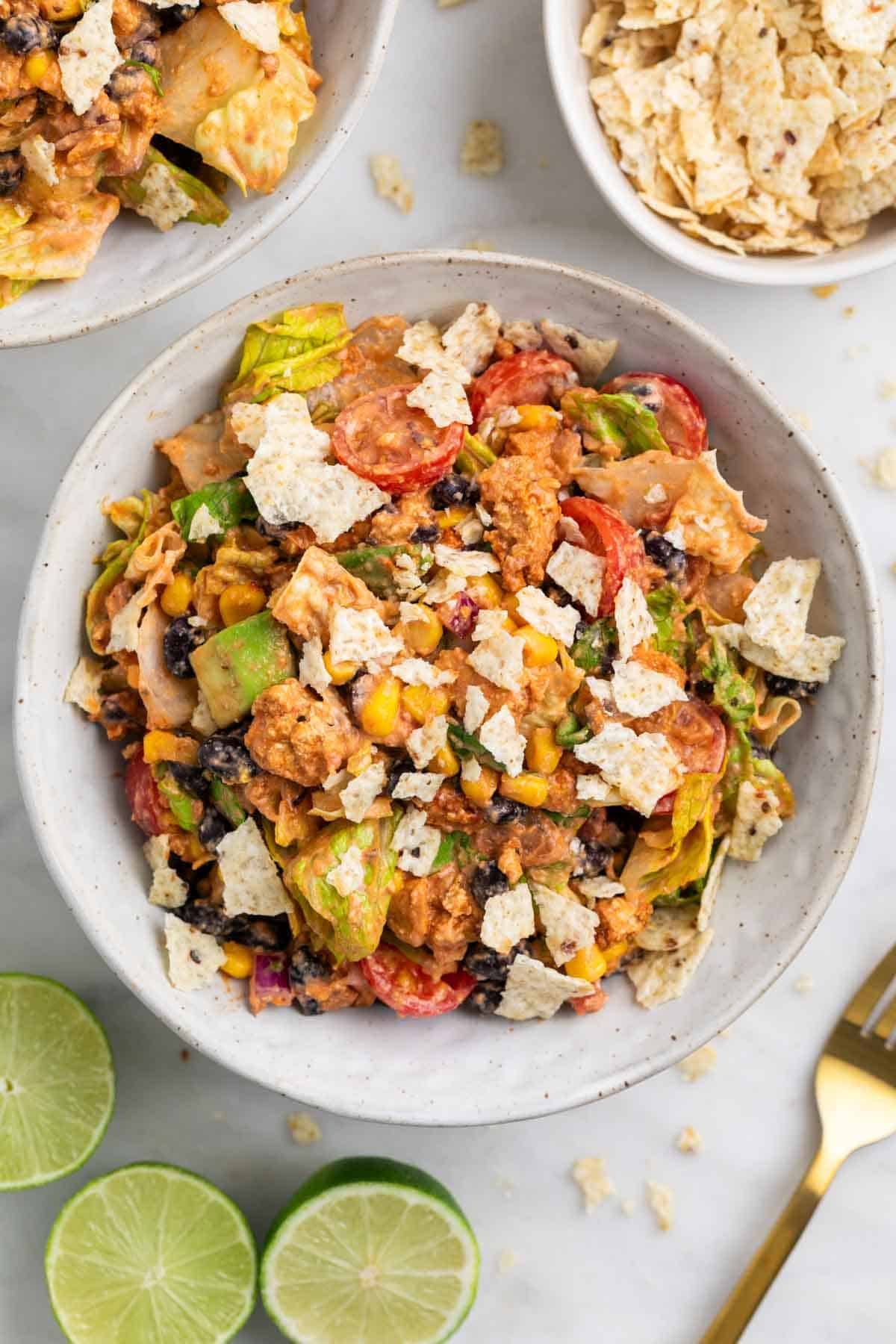 Two bowls of vegan taco salad with crushed tortilla chips