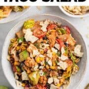 Bowls of vegan taco salad with avocado, black beans, and tortilla chips