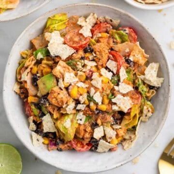 Vegan taco salad served with lime wedges and extra tortilla chips on the side