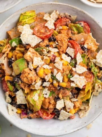 Vegan taco salad served with lime wedges and extra tortilla chips on the side