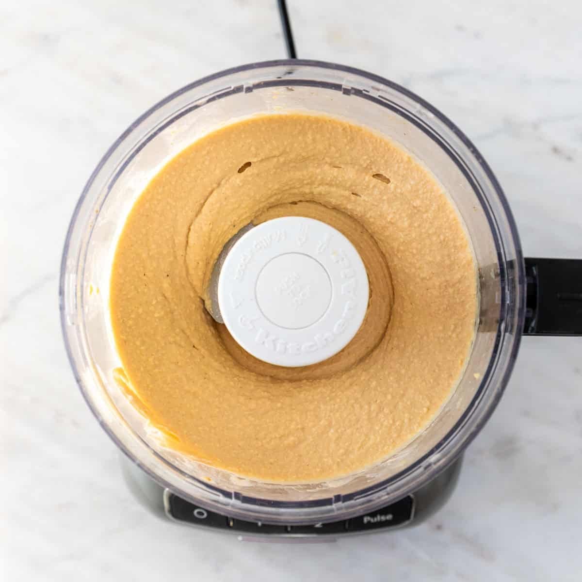 Homemade hummus blended in a food processor until smooth and creamy