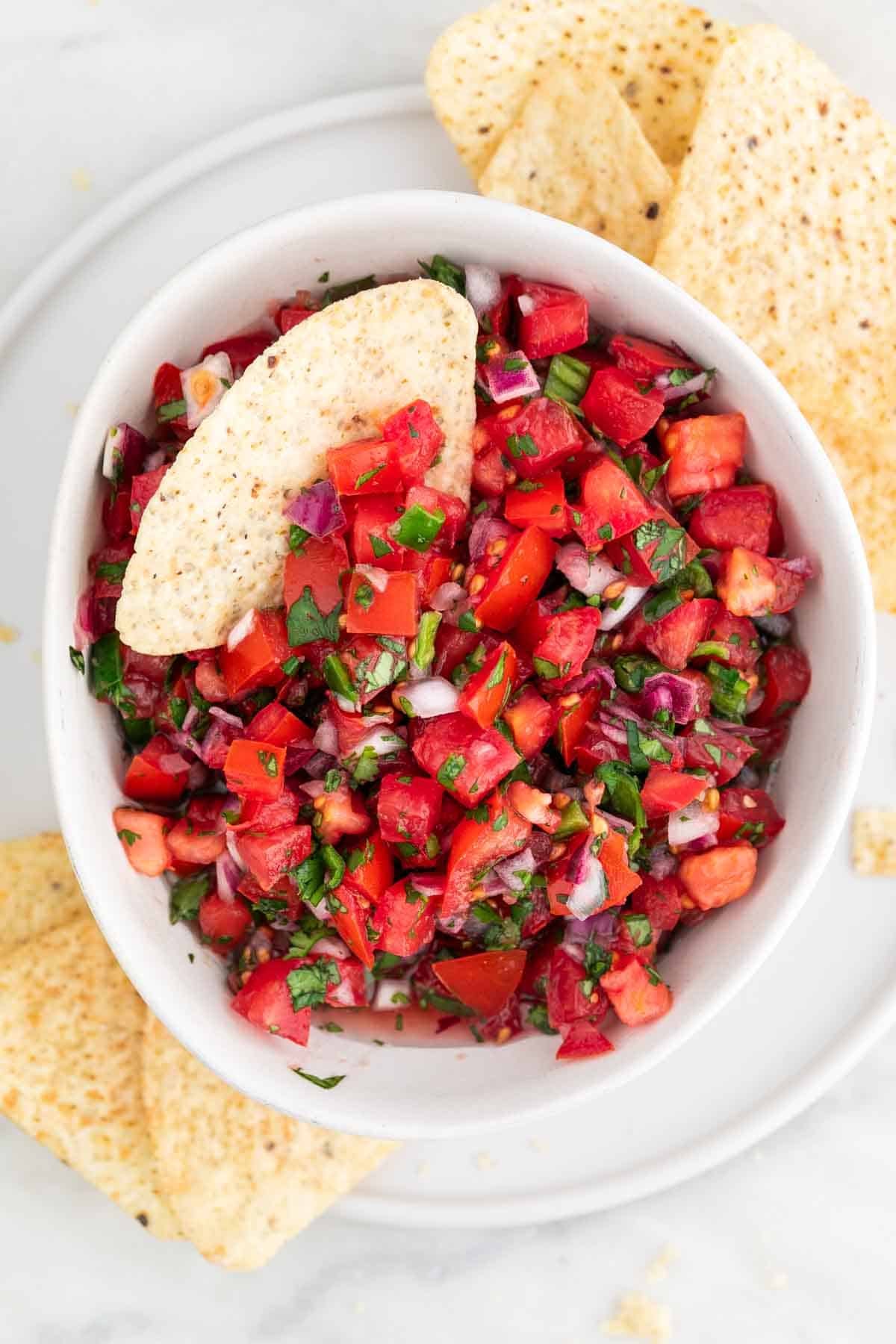 Bowl of homemade pico de gallo with crispy tortilla chips for dipping