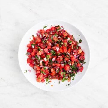 Pico de gallo mixed with lime juice and salt in a bowl
