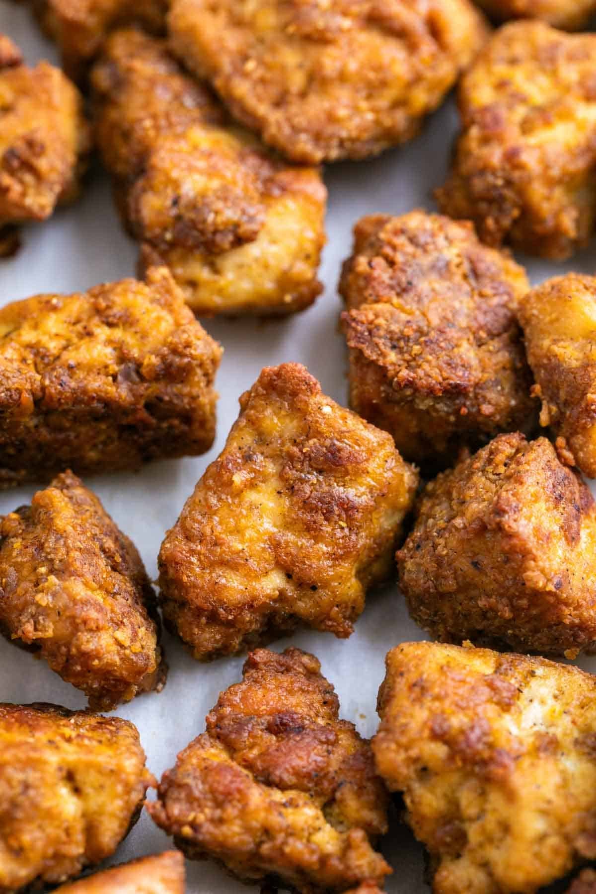 Golden brown tofu chicken pieces on a white background