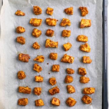 Crispy baked tofu chicken on a parchment-lined baking sheet