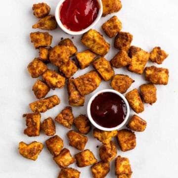 Tofu chicken served with BBQ sauce and ketchup on a white surface