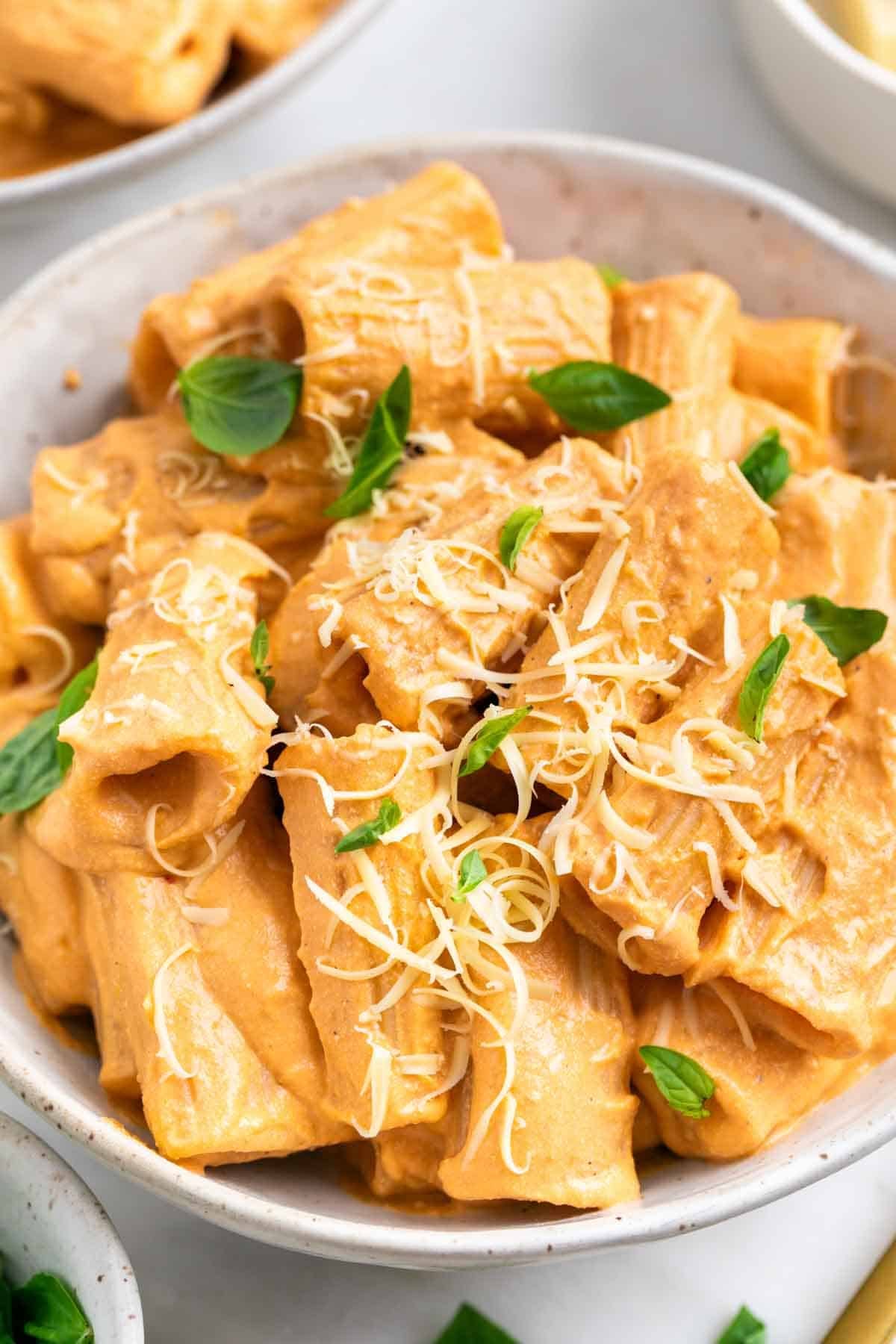 Creamy tofu pasta served with basil and vegan Parmesan cheese