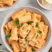 Homemade tofu pasta garnished with basil and vegan Parmesan