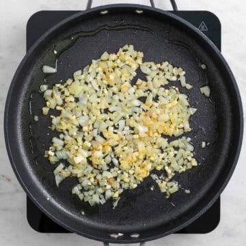 Onion and garlic cooking in a large skillet