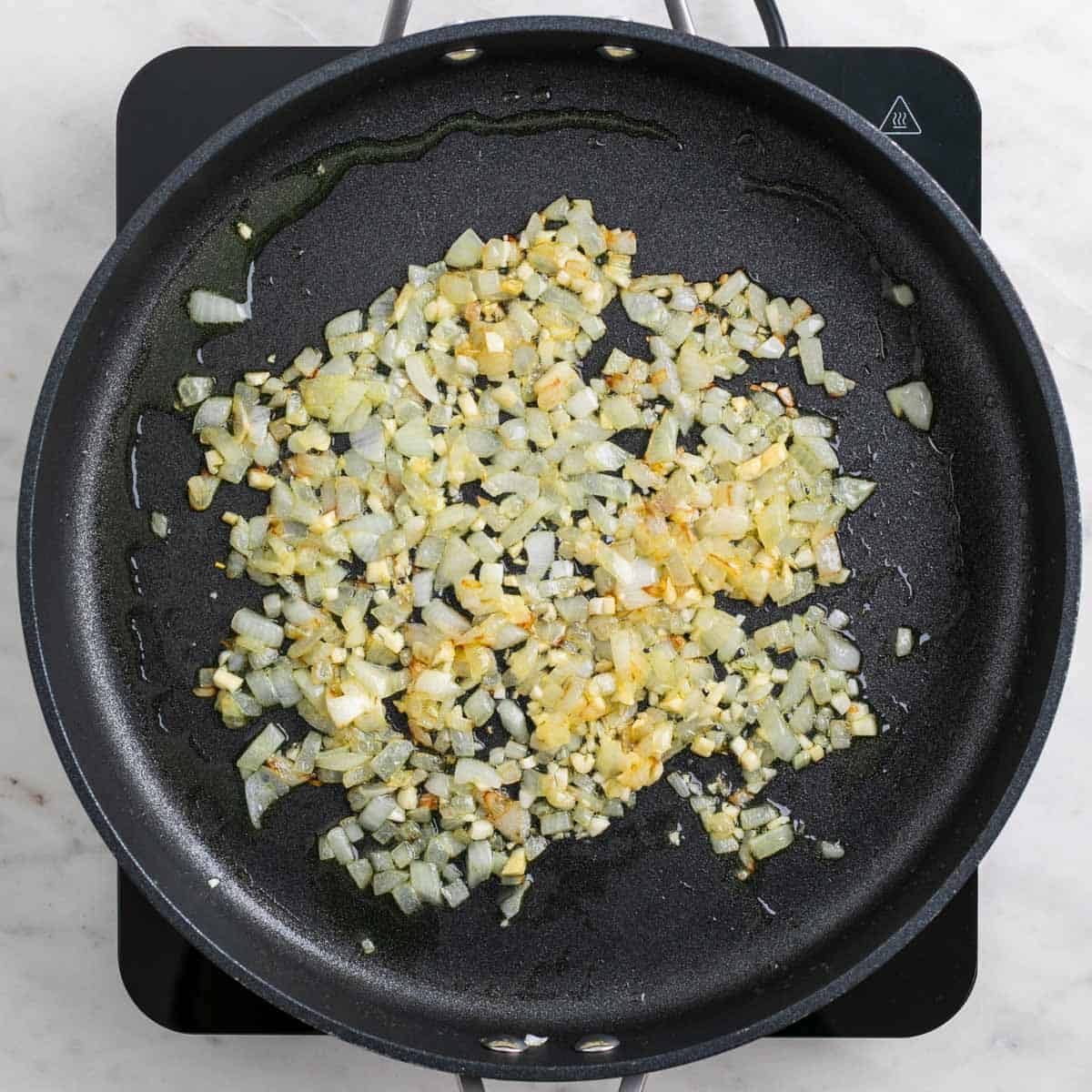 Onion and garlic cooking in a large skillet