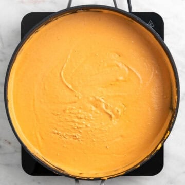 Creamy tofu tomato sauce cooking in a skillet