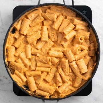 Rigatoni tossed with creamy tofu tomato sauce in a skillet