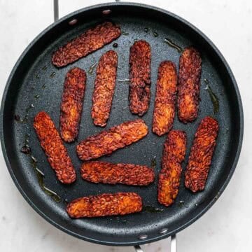 Vegan bacon cooking in a skillet