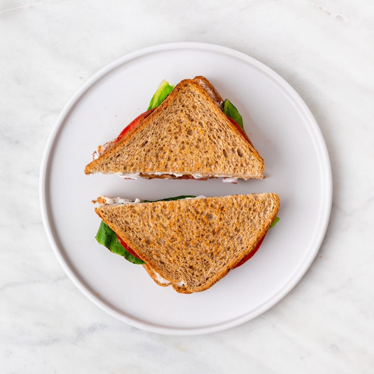 Assembled Vegan BLT sandwich cut in half and ready to serve