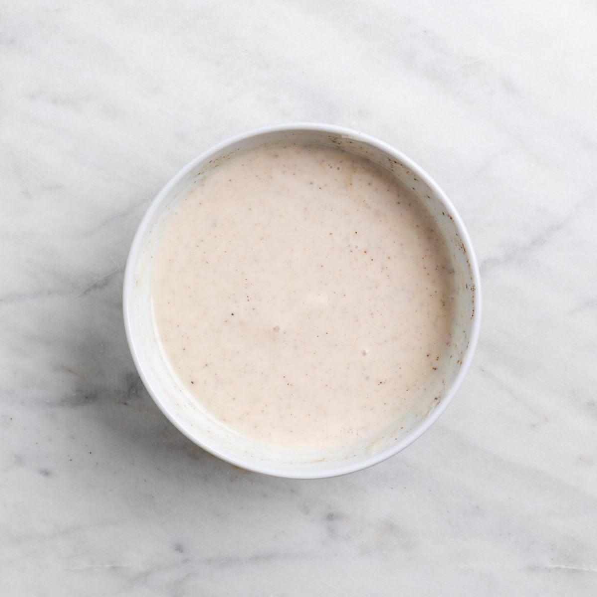 Creamy vegan broccoli salad dressing mixed in a small bowl