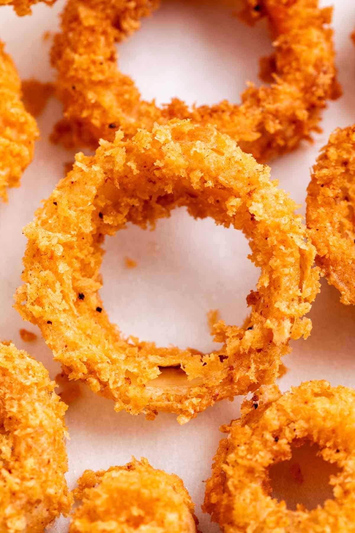 Crispy vegan onion rings on a white background