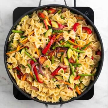 Vegan pasta primavera tossed in a skillet until glossy and creamy