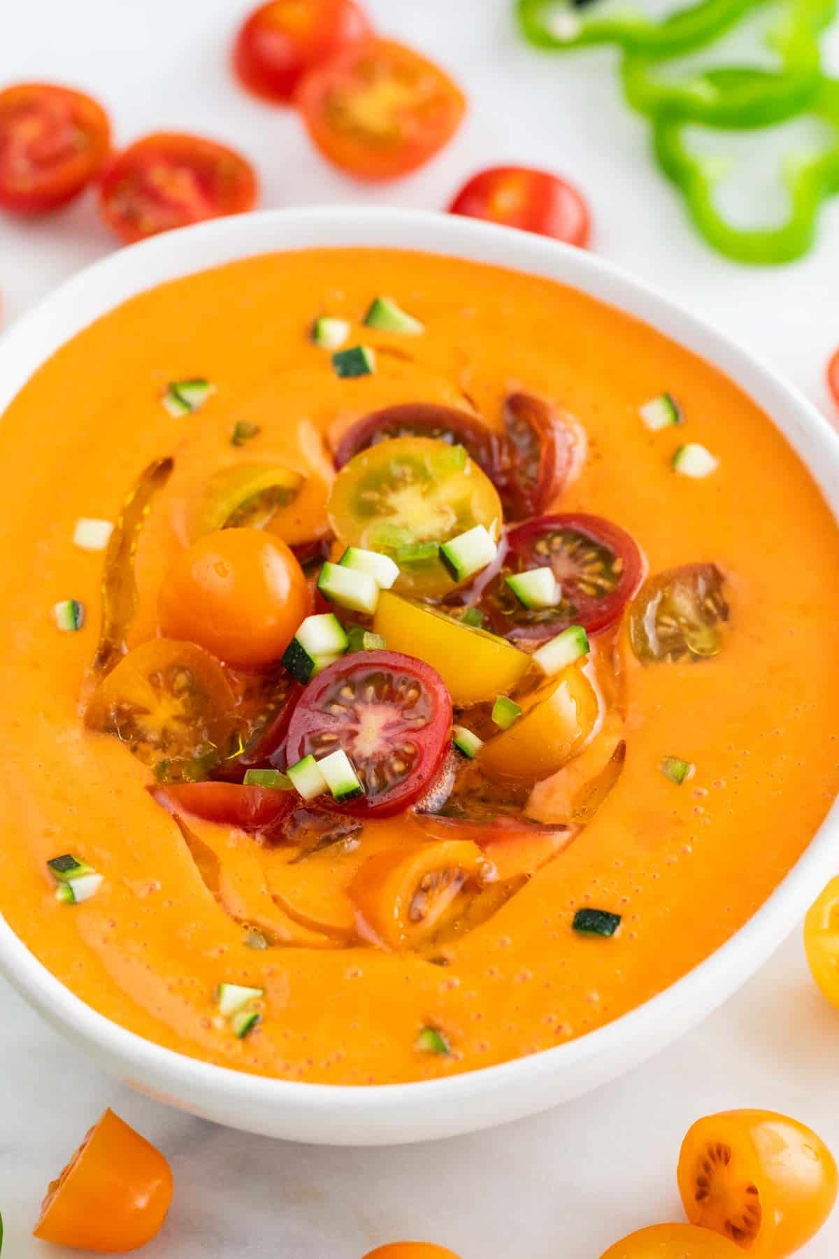 Spanish gazpacho topped with cherry tomatoes, cucumber, and a drizzle of olive oil