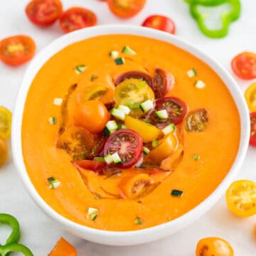 Bowl of chilled gazpacho with cherry tomatoes, cucumber, and a drizzle of olive oil