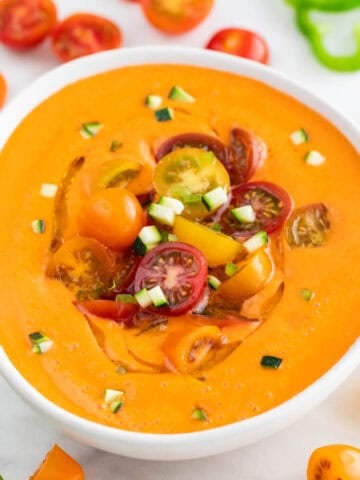 Bowl of chilled gazpacho with cherry tomatoes, cucumber, and a drizzle of olive oil