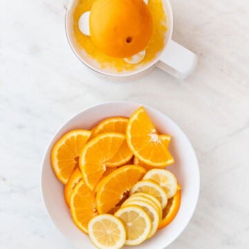 Orange juice, sliced orange, and sliced lemon prepared for sangria