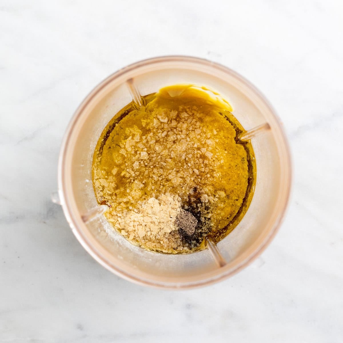 Ingredients for vegan salad dressing in a blender cup before mixing