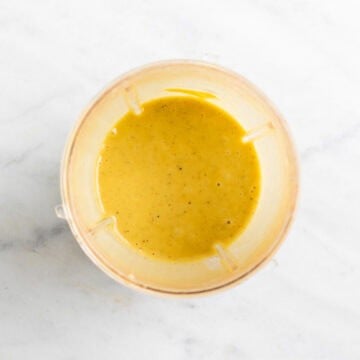 Creamy vegan salad dressing in a blender cup after blending